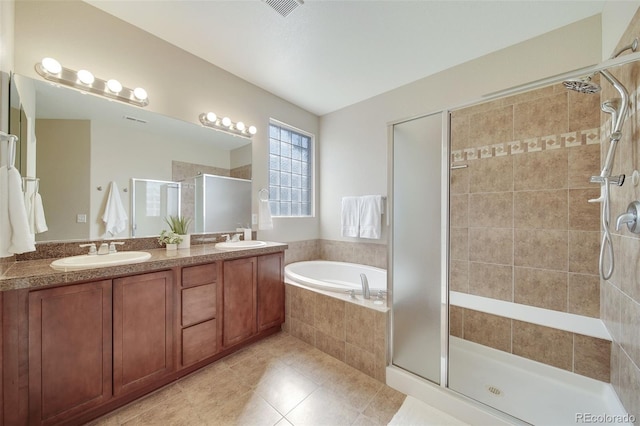 bathroom with tile patterned flooring, a sink, a bath, and a shower stall