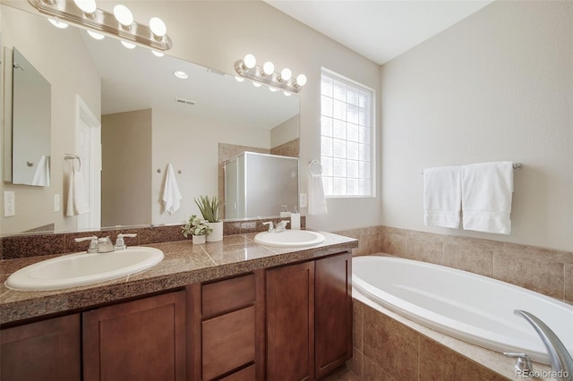 full bathroom featuring visible vents, a shower stall, a sink, and a bath