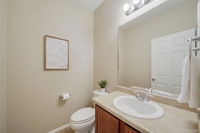 bathroom featuring vanity, baseboards, and toilet