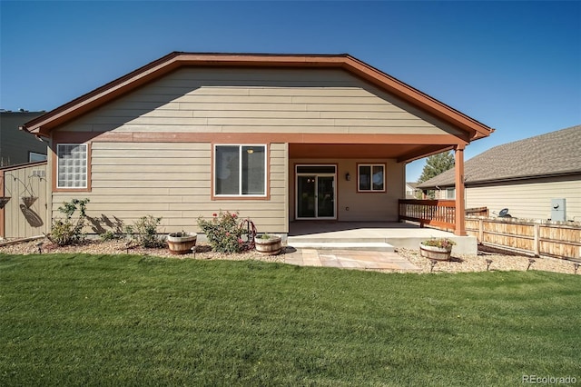 back of property with a lawn, fence, and a patio