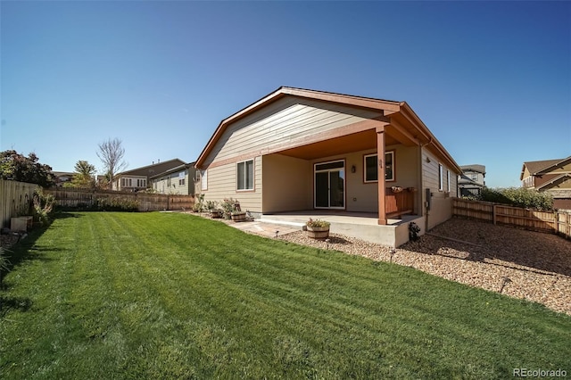 back of property with a fenced backyard, a patio, and a yard