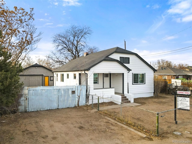 view of front facade with an outbuilding, a garage, and covered porch