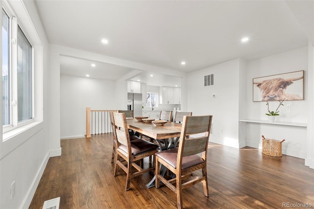 dining space with a wealth of natural light and dark hardwood / wood-style flooring