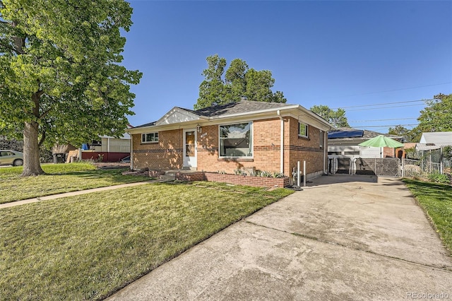 7060 Avrum Dr, Denver, CO 80221 - view of front of home featuring a gate, brick siding, and concrete driveway