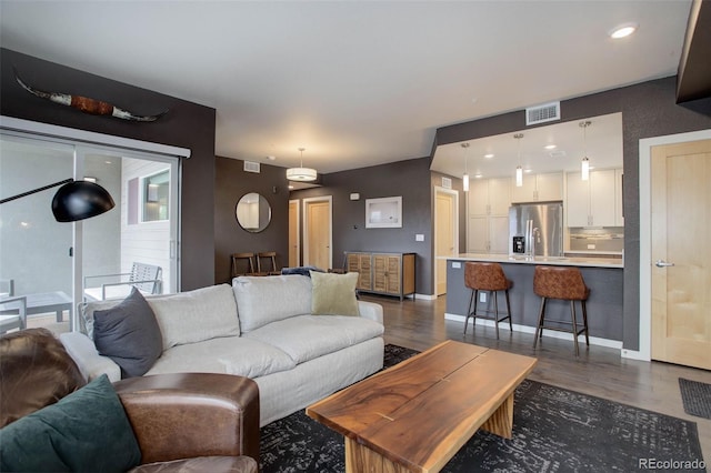 living area featuring dark wood finished floors, visible vents, recessed lighting, and baseboards