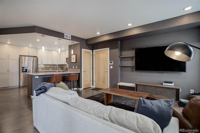 living room with recessed lighting, dark wood-style floors, and visible vents