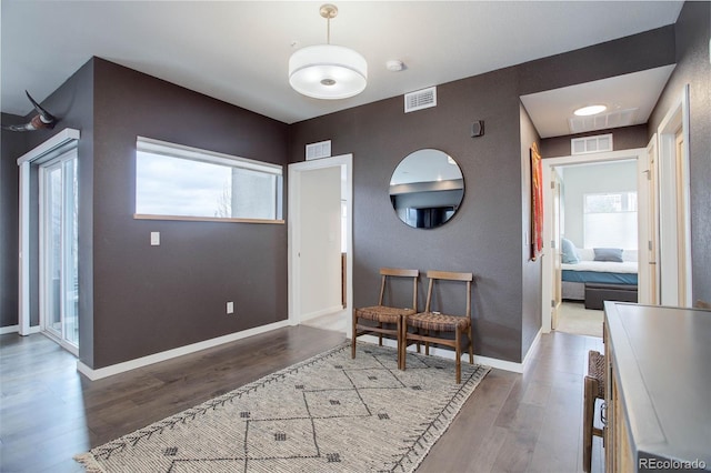 foyer featuring visible vents, baseboards, and wood finished floors