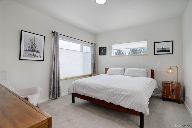 bedroom featuring baseboards and light colored carpet