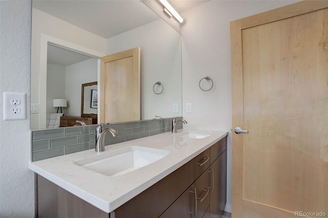 bathroom with a sink, decorative backsplash, and double vanity