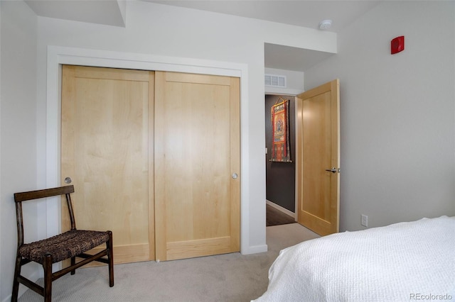 bedroom with a closet, baseboards, visible vents, and carpet flooring