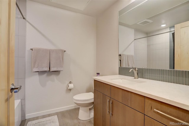 bathroom featuring visible vents, toilet, wood finished floors, baseboards, and vanity