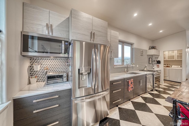 822 Yale Ave, Buena Vista, CO 81211 - kitchen featuring stainless steel appliances, independent washer and dryer, a sink, light floors, and tasteful backsplash