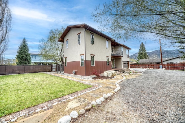 822 Yale Ave, Buena Vista, CO 81211 - rear view of house with a balcony, stucco siding, an attached garage, a mountain view, and driveway