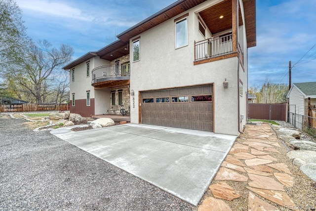 822 Yale Ave, Buena Vista, CO 81211 - rear view of house with a balcony, a garage, stucco siding, concrete driveway, and fence