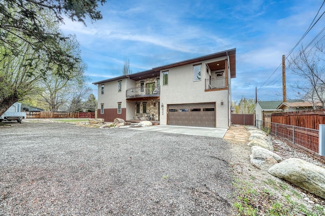 822 Yale Ave, Buena Vista, CO 81211 - view of front of home with a balcony, stucco siding, a garage, gravel driveway, and fence