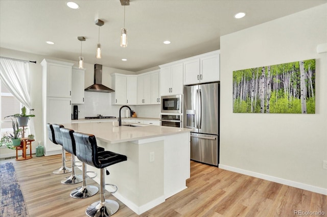 11205 W 53rd Ln, Arvada, CO 80002 - kitchen with stainless steel appliances, wall chimney exhaust hood, a sink, light countertops, and recessed lighting