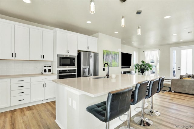 11205 W 53rd Ln, Arvada, CO 80002 - kitchen featuring stainless steel appliances, a sink, open floor plan, light wood-style floors, and recessed lighting