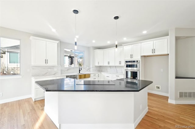 kitchen with visible vents, tasteful backsplash, white cabinetry, stainless steel double oven, and black electric cooktop