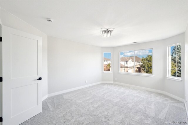 carpeted spare room featuring baseboards