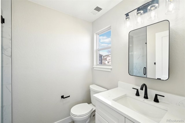 bathroom featuring vanity, baseboards, visible vents, a marble finish shower, and toilet