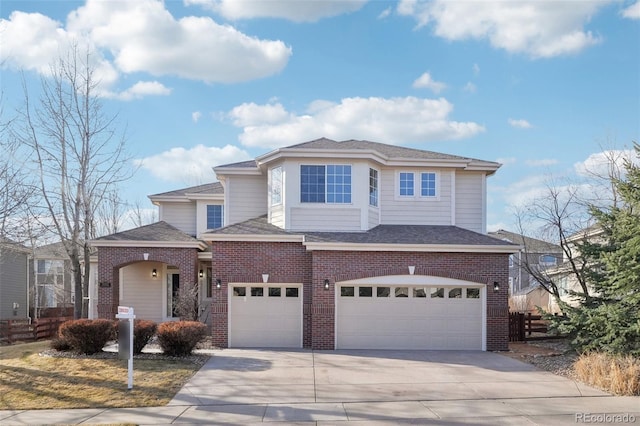 traditional home featuring brick siding, an attached garage, concrete driveway, and fence