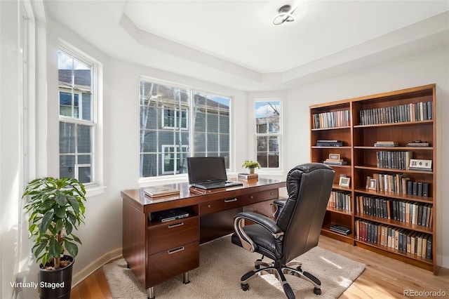 office with a raised ceiling, baseboards, and wood finished floors