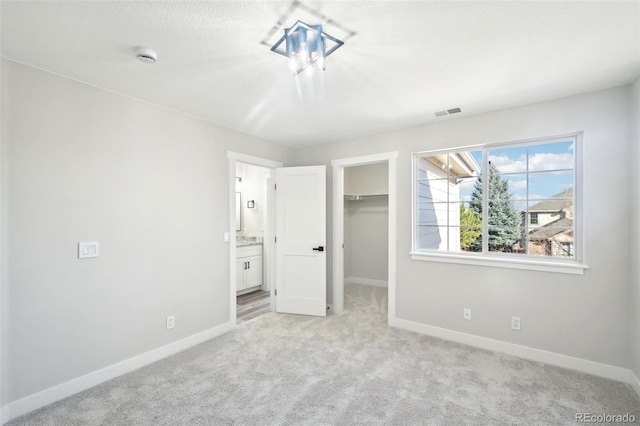 5352 Brookside Dr, Broomfield, CO 80020 - unfurnished bedroom with light colored carpet, baseboards, a walk in closet, a closet, and connected bathroom