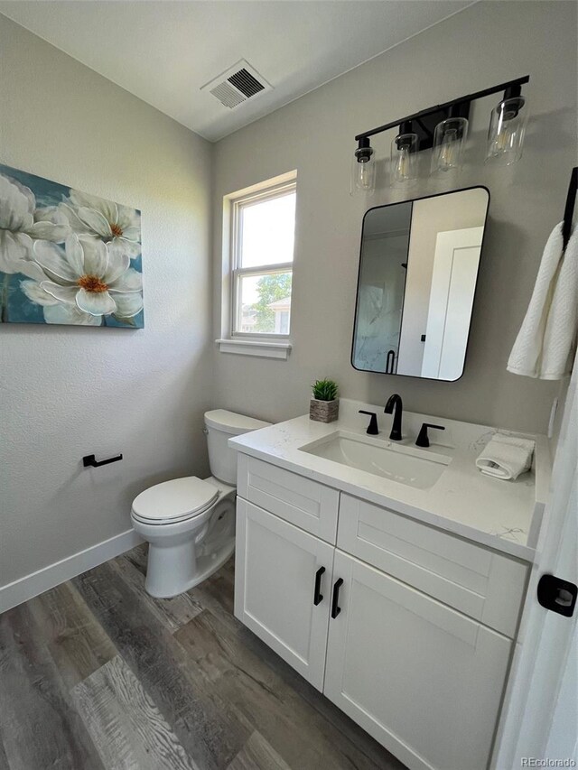 5352 Brookside Dr, Broomfield, CO 80020 - half bath with wood finished floors, vanity, toilet, and baseboards