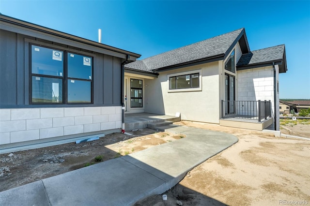 ranch-style house with roof with shingles and concrete block siding