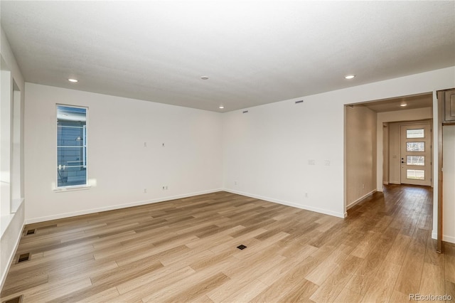 unfurnished room featuring light hardwood / wood-style floors and a textured ceiling