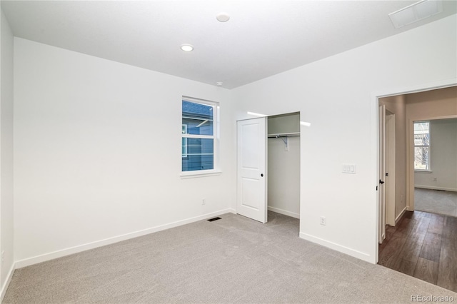 unfurnished bedroom with light wood-type flooring and a closet