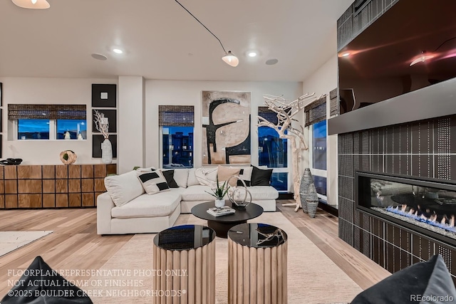 living room featuring a tile fireplace and hardwood / wood-style floors