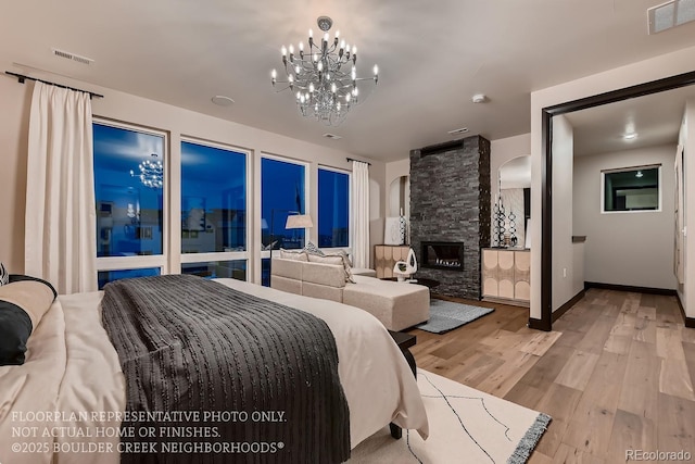 bedroom with light hardwood / wood-style flooring and a fireplace