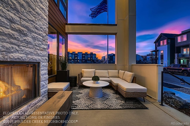 patio terrace at dusk featuring an outdoor living space with a fireplace