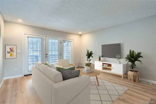 living room featuring light hardwood / wood-style floors and a textured ceiling