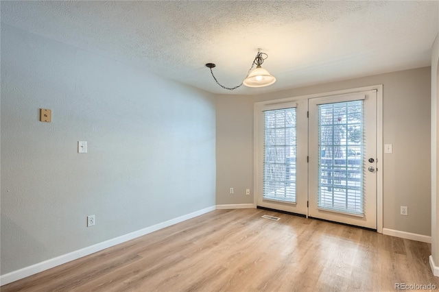 doorway featuring a textured ceiling and light wood-type flooring