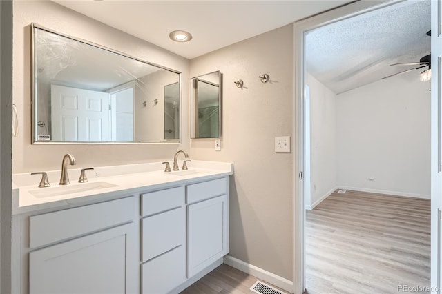 bathroom featuring a textured ceiling, vanity, ceiling fan, and hardwood / wood-style floors