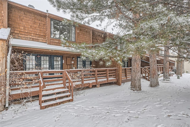 view of snow covered back of property