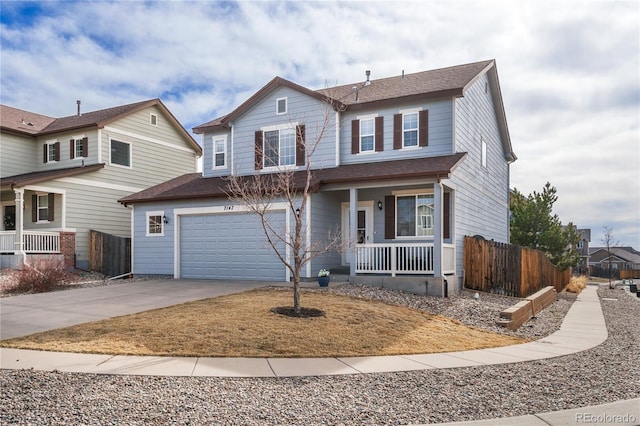 traditional home with a porch, an attached garage, fence, and driveway