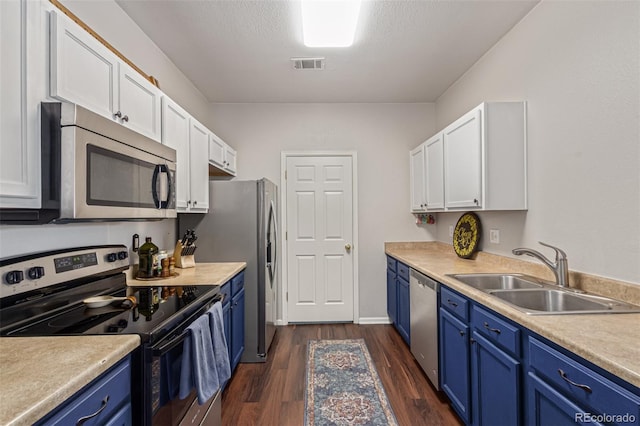 4451 S Ammons St Unit 5-307, Littleton, CO 80123 - kitchen with stainless steel appliances, blue cabinets, white cabinetry, and dark wood finished floors
