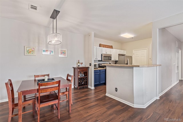 4451 S Ammons St Unit 5-307, Littleton, CO 80123 - kitchen with stainless steel appliances, blue cabinetry, dark wood-style flooring, and decorative light fixtures