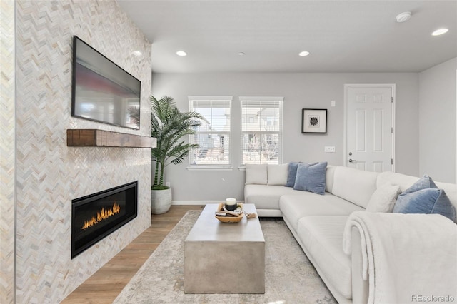 living room with a tile fireplace, baseboards, recessed lighting, and wood finished floors