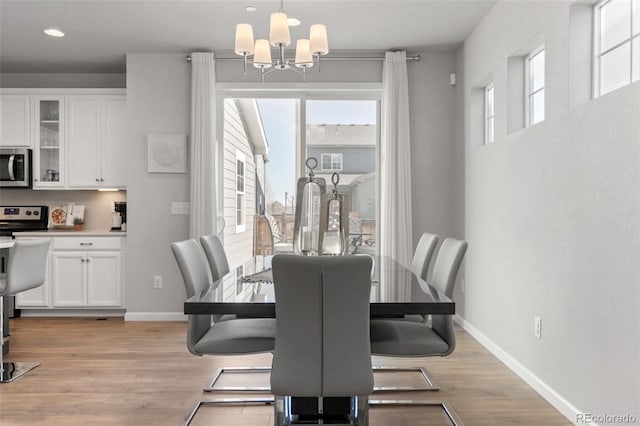 dining area featuring an inviting chandelier, light wood-style flooring, baseboards, and recessed lighting