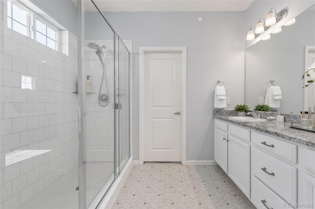 full bath featuring a stall shower, baseboards, and vanity