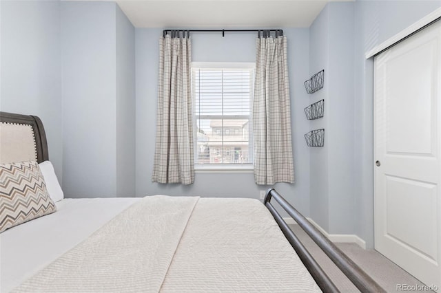 carpeted bedroom with baseboards and a closet