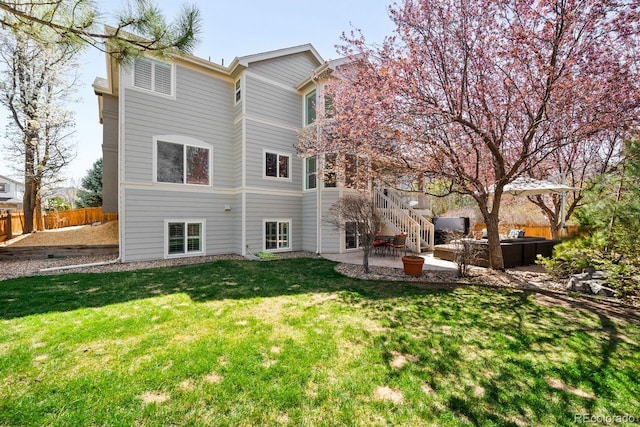 rear view of house with a patio area, fence, stairway, and a lawn