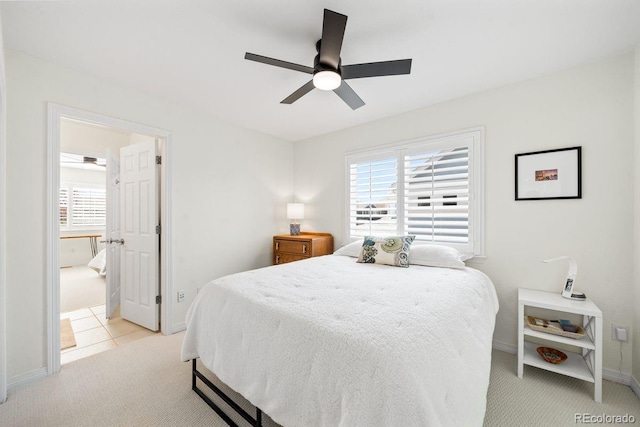bedroom featuring light carpet, multiple windows, baseboards, and a ceiling fan