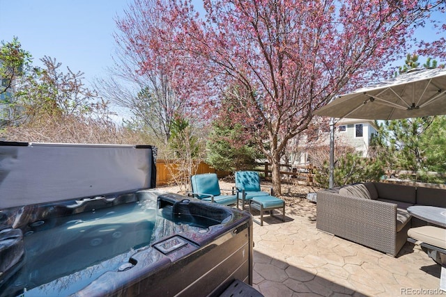 view of patio featuring fence, a hot tub, and an outdoor hangout area