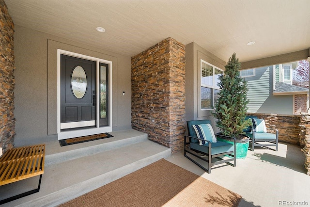 view of exterior entry with stone siding and stucco siding