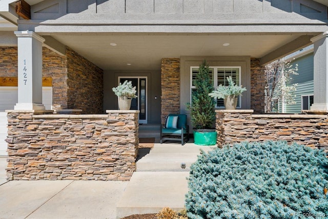 entrance to property featuring a porch and stone siding